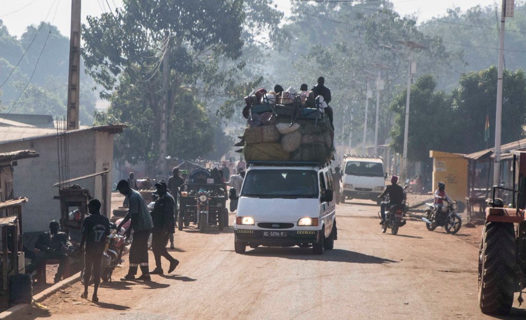 With a load as tall as the car itself and men standing on the roof
